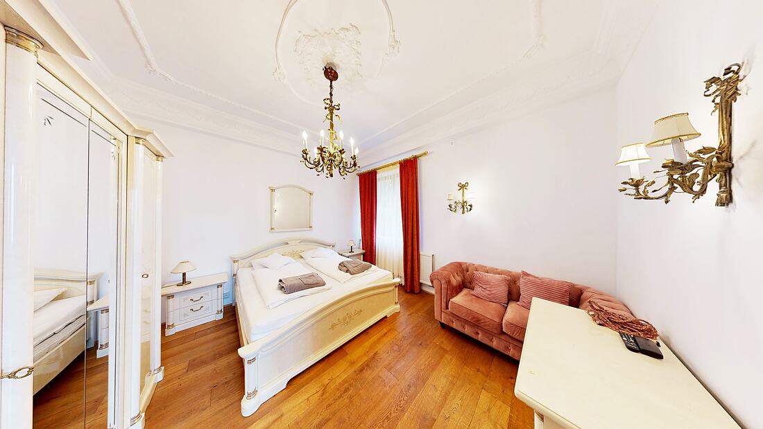 Room 0 — the master bedroom, chandelier and parquet floor.