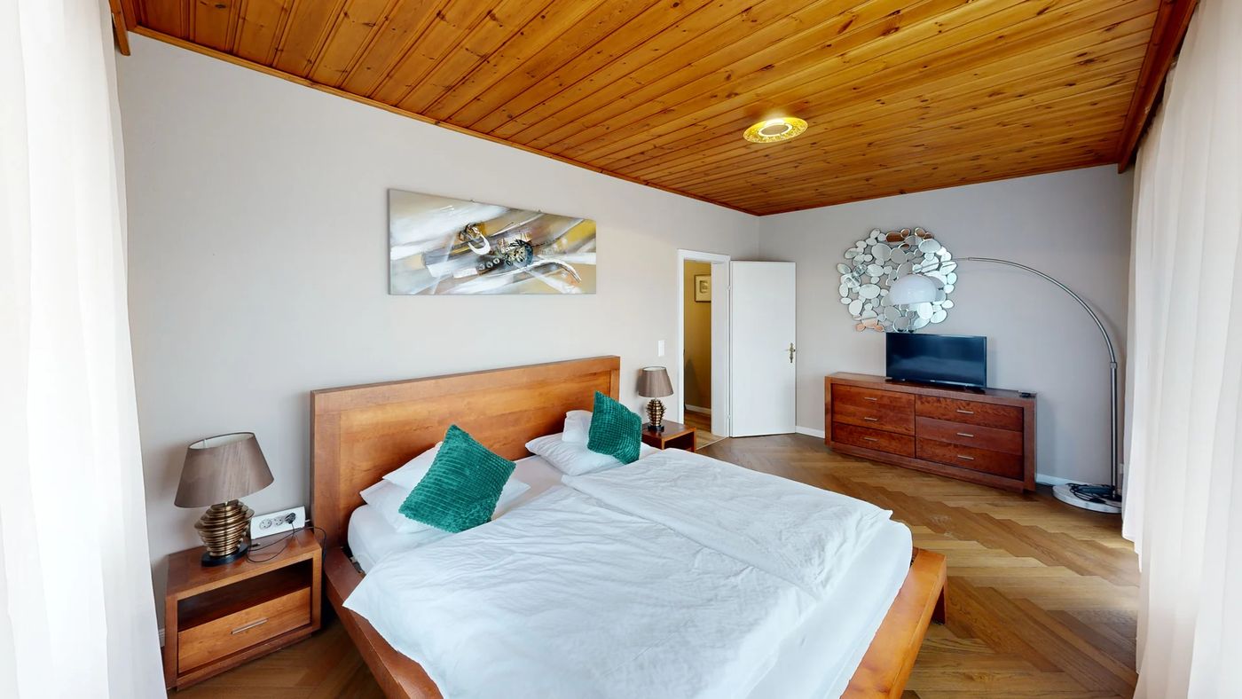 Room 3 — walnut bed under a pine ceiling, with a television.