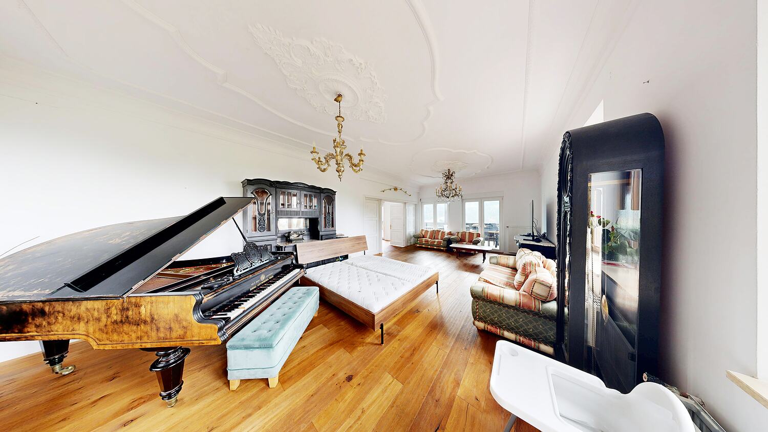 Salon with a grand piano and long sofas.